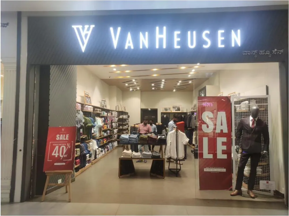Illuminated Van Heusen storefront name board in a shopping mall