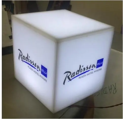 Illuminated cube sign for a hotel brand seen in daylight