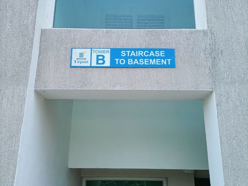 Blue sign above a tower entrance reading Tower B, Staircase to basement