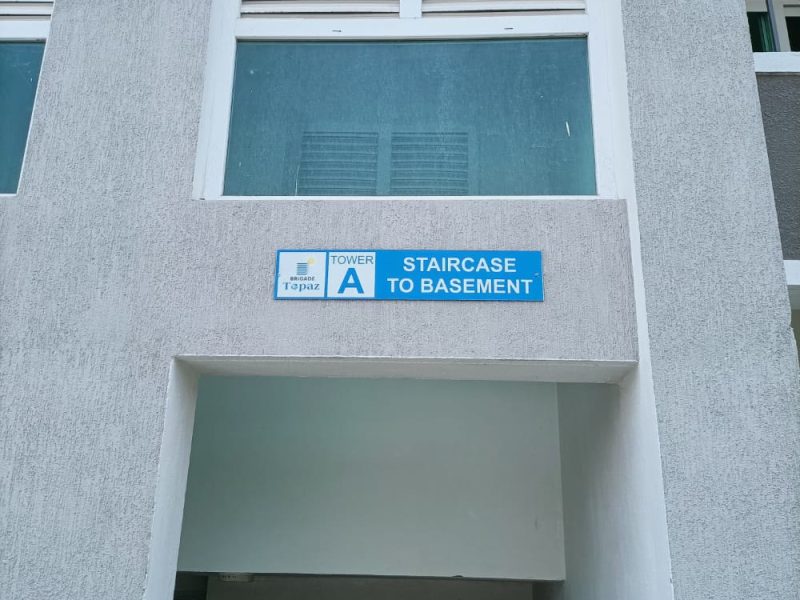 Blue sign above a tower entrance reading Tower A, Staircase to basement