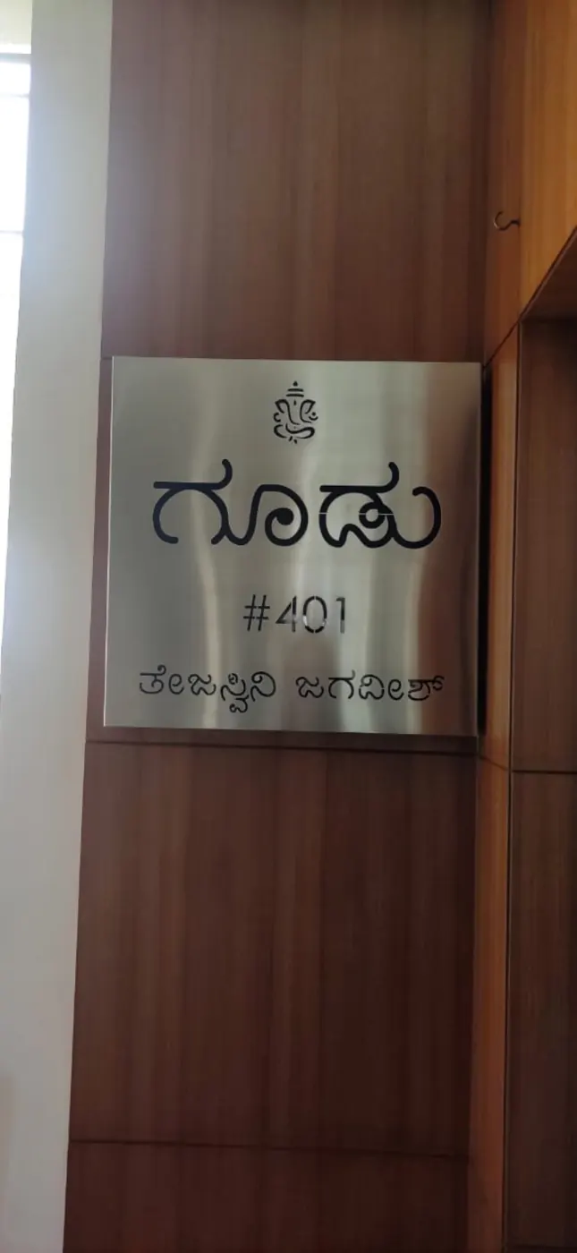Goodu stainless steel name plate in daylight, name in Kannada