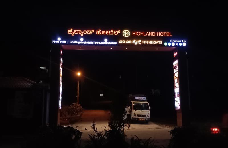 Highland Hotel entrance arch at night with the name lit