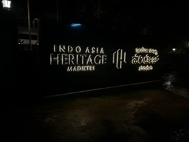 Indo Asia Heritage entrance sign, stainless steel letters glowing at night, Madikeri