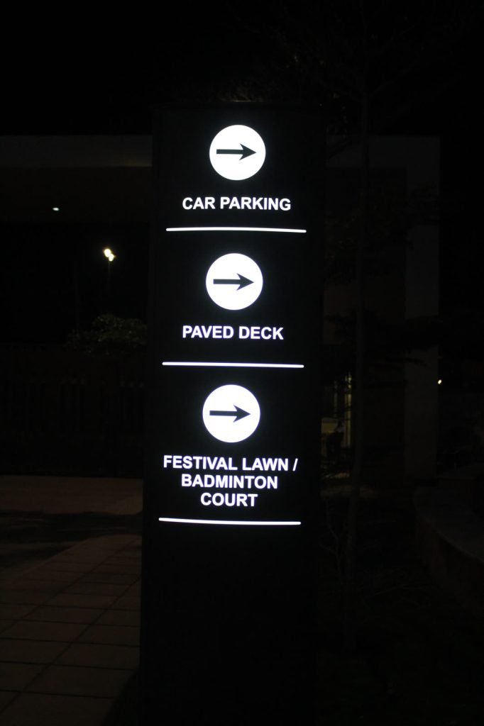 Lit direction totem with arrows to Car Parking, Paved Deck and Festival Lawn