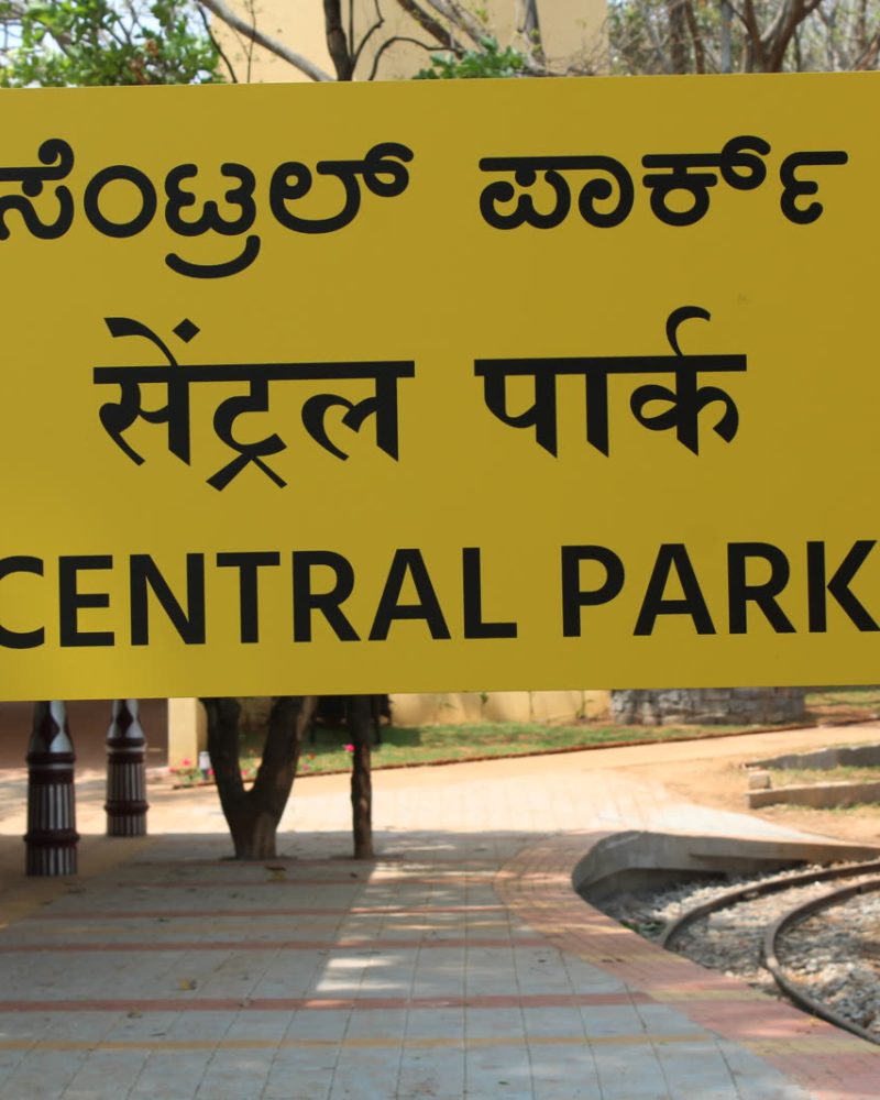 Yellow station-style name board reading Central Park in Kannada, Hindi and English