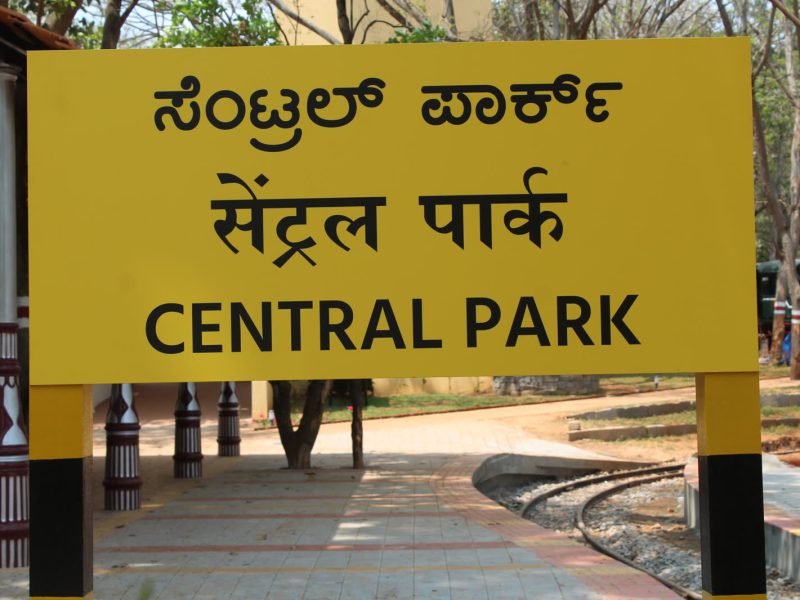 Yellow station-style name board reading Central Park in Kannada, Hindi and English