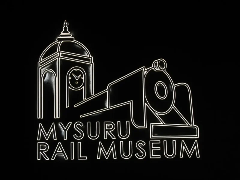 Mysuru Rail Museum entrance logo, outline letters lit at night