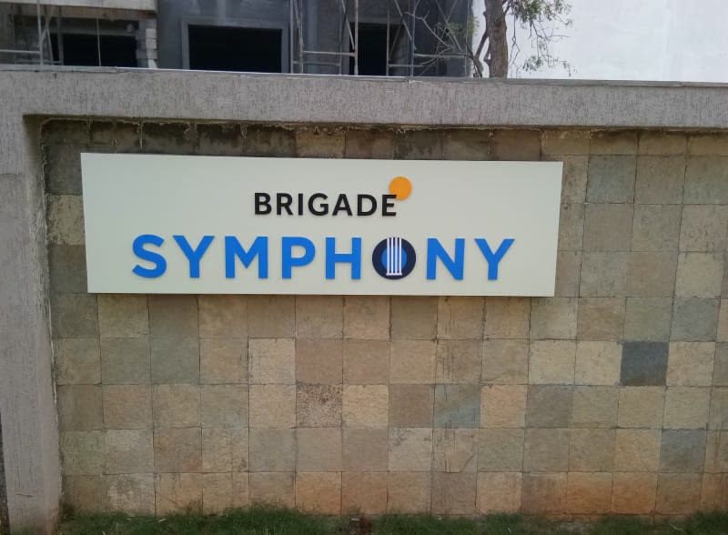 Brigade Symphony name board on a stone-clad compound wall