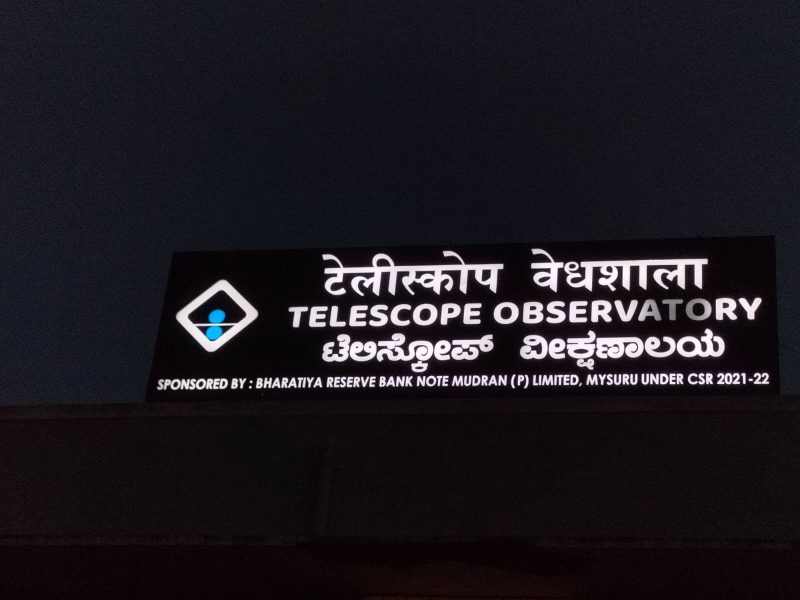 Telescope Observatory board in Hindi, English and Kannada, lit at night