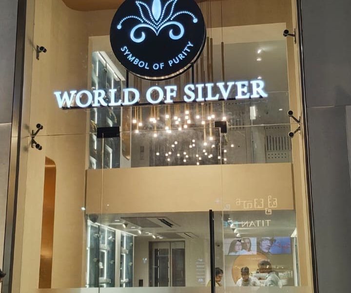 World of Silver showroom front with lit letters and a round logo, at night