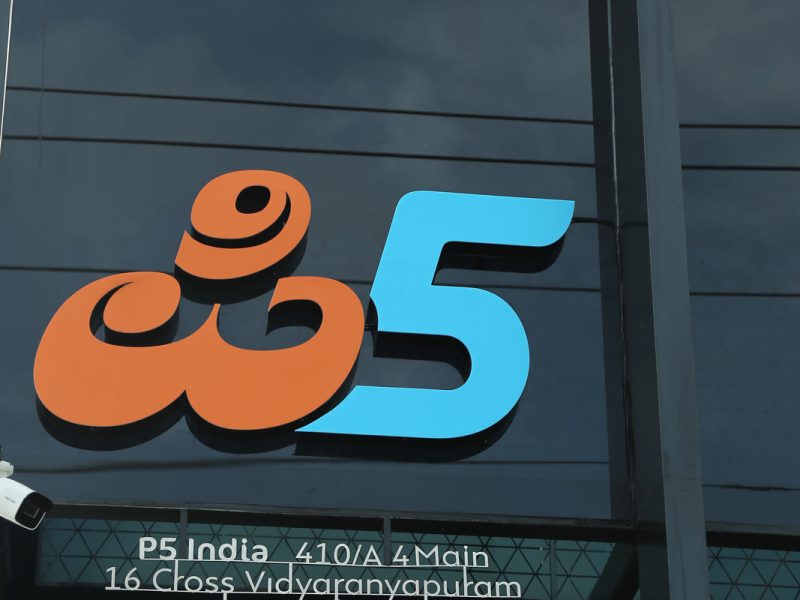 Raised orange and blue P5 logo letters on the dark glass front, with the address strip below