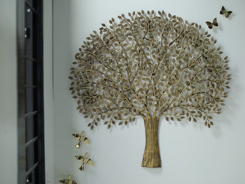 Gold-finish cut-metal tree with butterflies and birds on a white wall