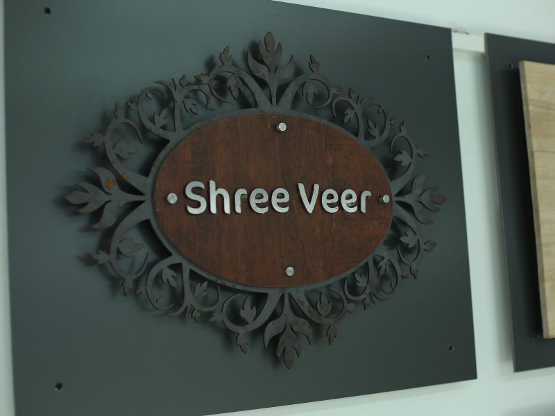 Shree Veer name plate: white letters on a wood-look oval inside a carved grey frame