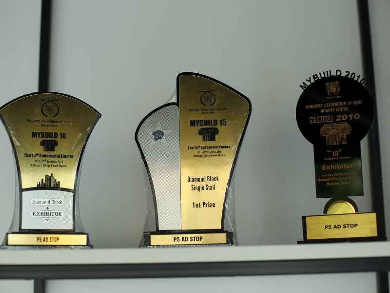 Three trophies on a shelf from the MYBUILD exhibitions of the Builders' Association of India, Mysore Centre