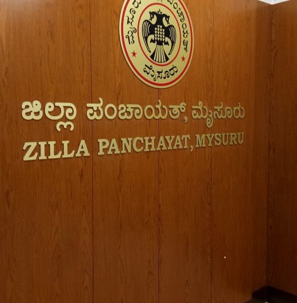 Zilla Panchayat, Mysuru: gold letters and emblem on a wood-panelled reception wall